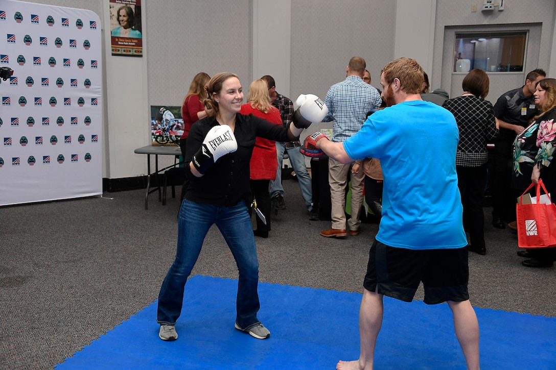 Kristy Hardin (left) throws some training punches with MWR Personal Trainer Chisholm.