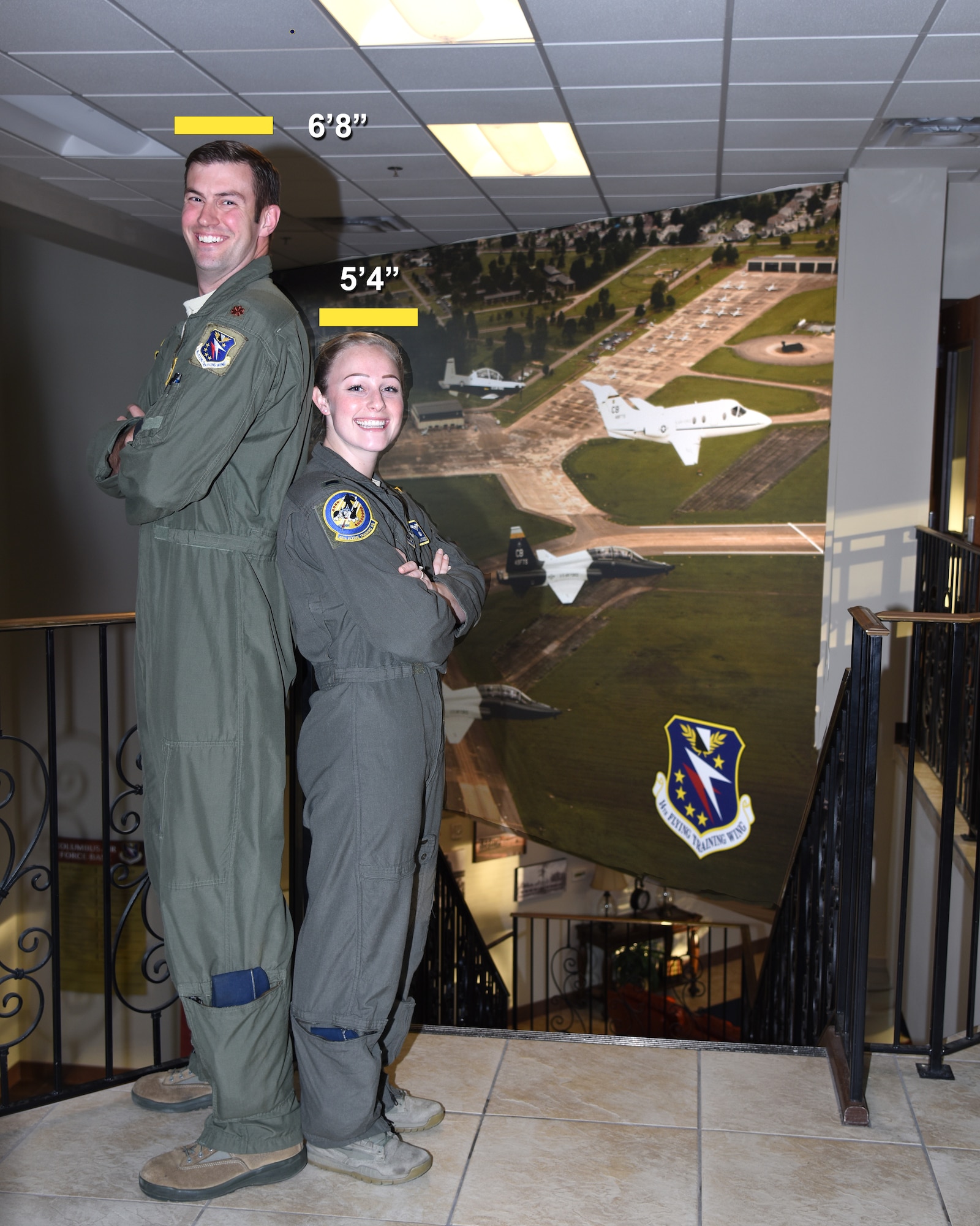 Maj. Nate and 1st Lt. Christina Nicholson, 48th Flying Training Squadron instructor pilot, stand next to each other to show their height difference Oct. 30, 2019, on Columbus Air Force Base, Miss. The standing height requirements to become a pilot are a minimum 5 feet 4 inches and maximum 6 feet 5 inches, but can be dismissed through the waiver process. (U.S. Air Force photo by Sharon Ybarra)