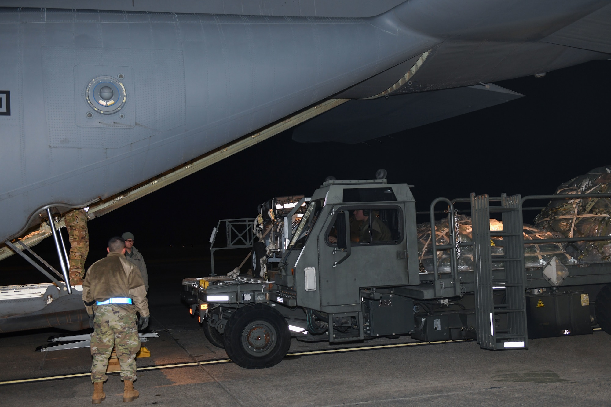 People push cargo in a plane.