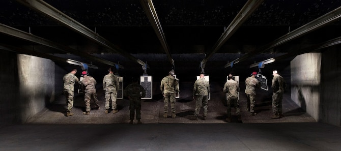 U.S. Air Force combat arms instructors and participants look over practice targets at an inaugural M9 pistol Excellence in Competition shooting event at the Combat Arms range complex at Shaw Air Force Base, South Carolina, Nov. 6, 2019.