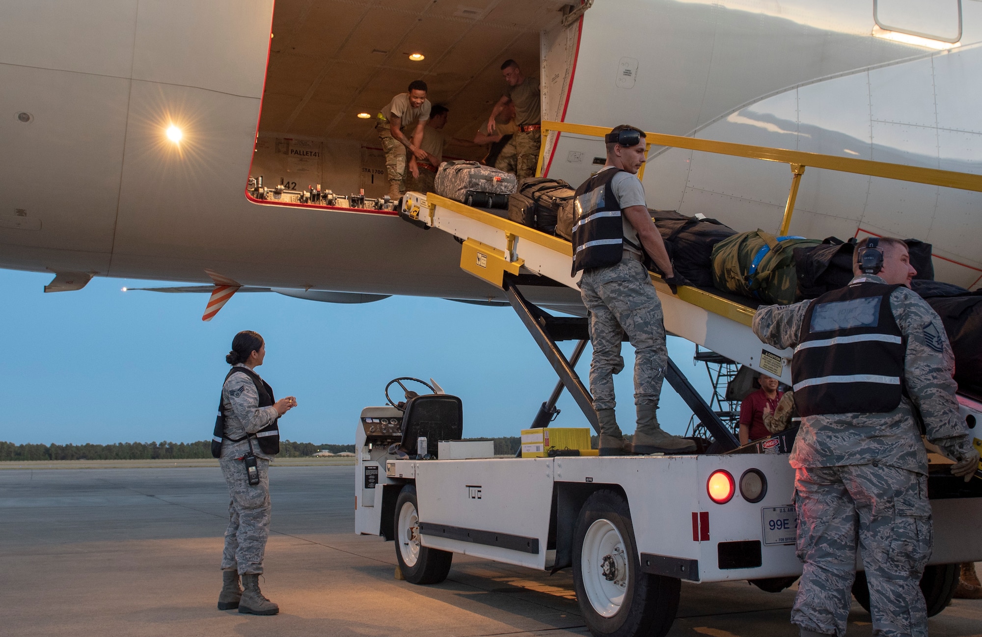 From left, U.S. Air Force Senior Airman Andrea Cardenas, Airman 1st Class Justen McCallister, 20th Logistics Readiness Squadron (LRS) aerial transportation specialists, and Master Sgt. Christopher Deibel, 20th LRS mobility instructor, monitor baggage moving into the cargo hold of a Boeing 777 at Shaw Air Force Base, South Carolina, Oct. 17, 2019.