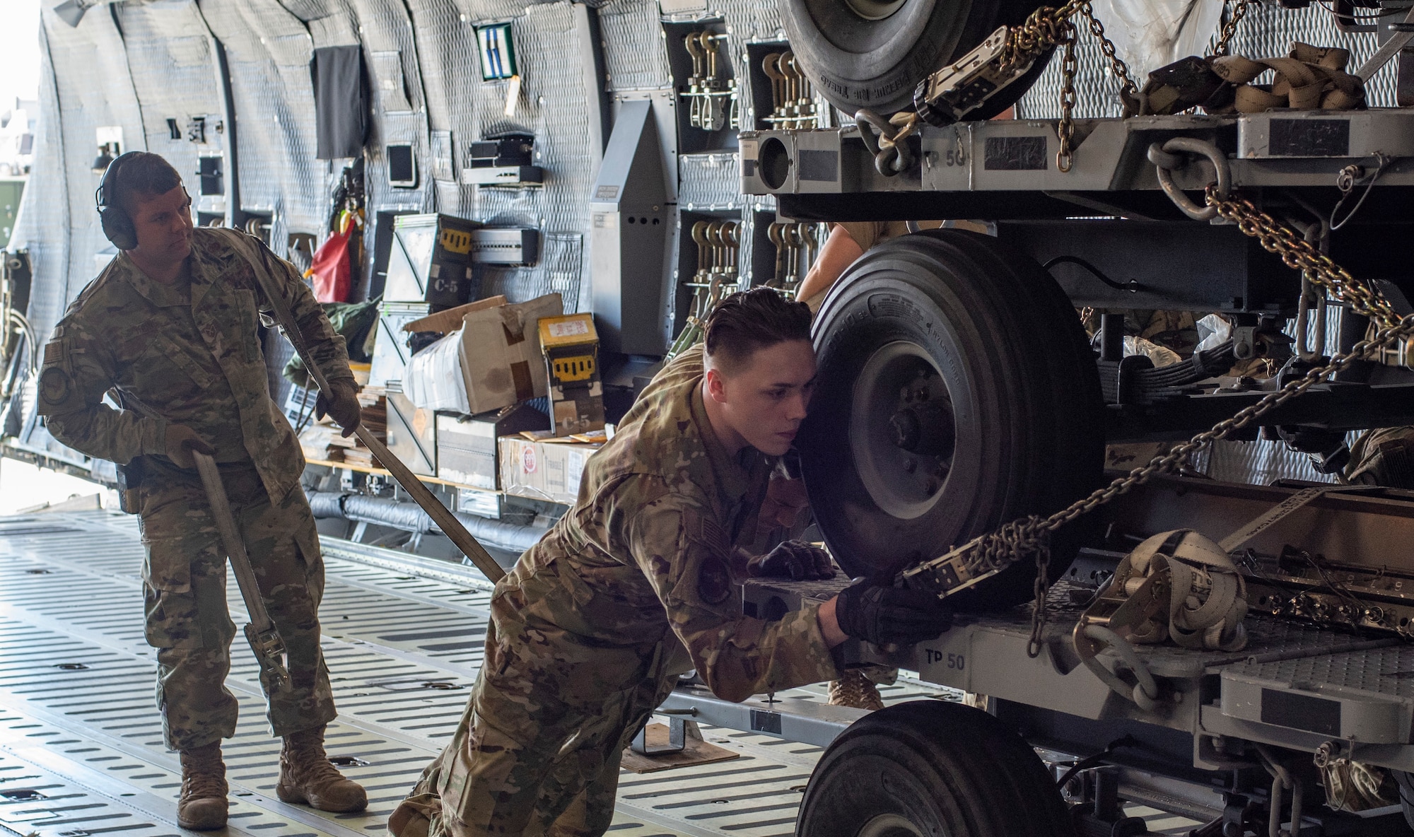 From left, U.S. Air Force Tech. Sgt. William Young, a 20th Logistics Readiness Squadron aerial transportation specialist, and Senior Airman Brandon Driver, 9th Airlift Squadron loadmaster, load cargo onto a C-5M Super Galaxy, at Shaw Air Force Base, South Carolina, Oct. 24, 2019.
