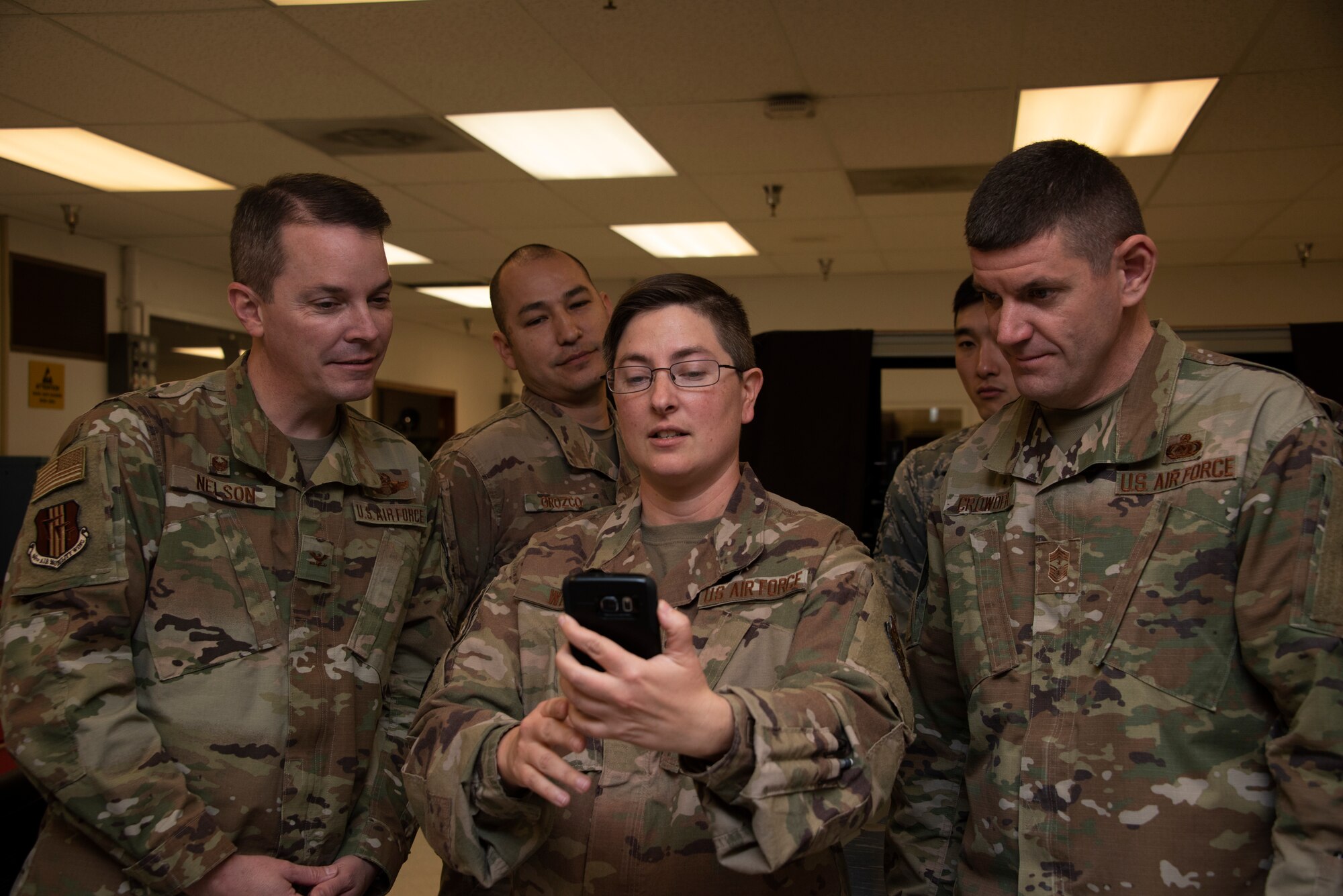 U.S. Air Force Tech. Sgt. Karen White, center right, 60th Maintenance Squadron avionics flight chief, center, shows Col. Jeff Nelson, left, 60th Air Mobility Wing commander, and Chief Master Sgt. Derek Crowder, right, 60th AMW command chief, images on her phone of C-17 Globemaster III maintenance equipment Nov. 1, 2019, during a Leadership Rounds visit at Travis Air Force Base, California. The Leadership Rounds program provides 60th AMW leadership an opportunity to interact with Airmen to get a detailed view of each mission performed at Travis AFB. (U.S. Air Force photo by Tech. Sgt. James Hodgman)