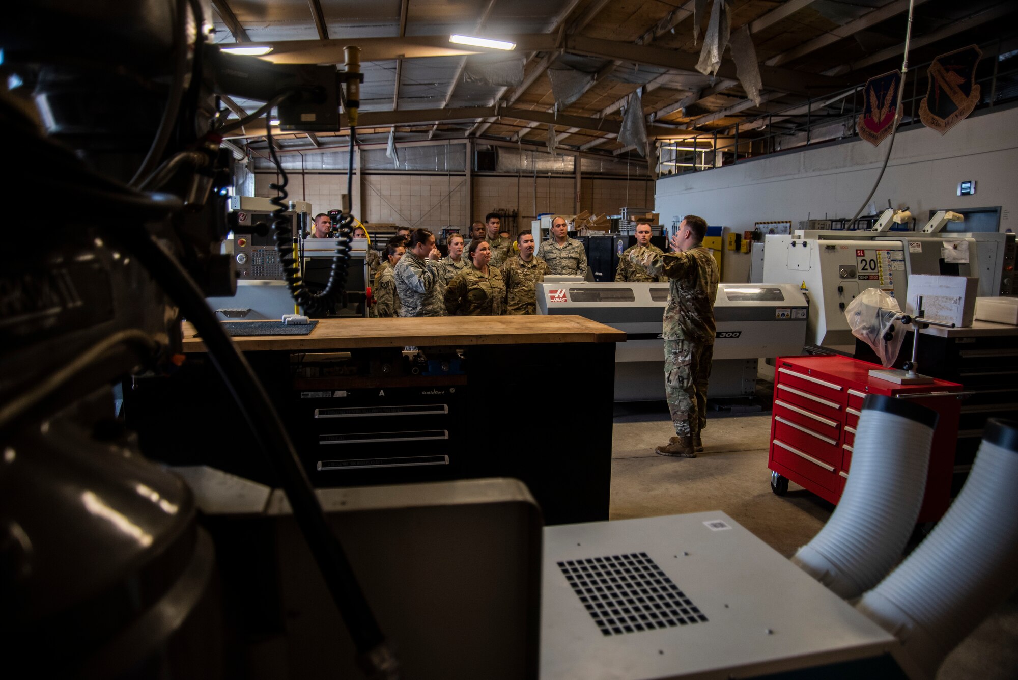 First lieutenant Matthew Gill, 53rd Test Support Squadron special devices engineering section chief, facilitates an immersion tour at the special devices flight metal fabrication shop for members assigned to the 325th Fighter Wing on Nov. 8, 2019, at Tyndall Air Force Base, Florida. Airmen visited multiple units of the 53rd Weapons Evaluation Group during the tour. The group was also participating in the Weapons System Evaluation Program and Checkered Flag 20-1 exercise on Tyndall's flight line. Attendees also learned about the unit's joint partnership with Tyndall, ensuring Airmen are trained and equipment is tested, to support the warfighter. (U.S. Air Force photo by Staff Sgt. Magen M. Reeves)