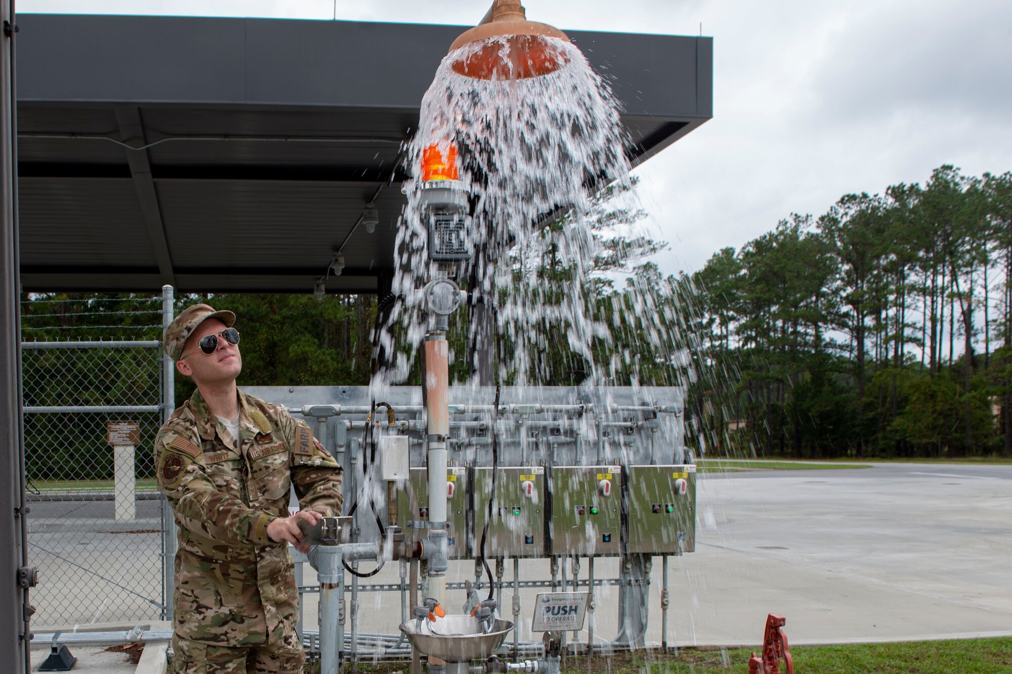A photo of an Airman testing an emergency eye wash station