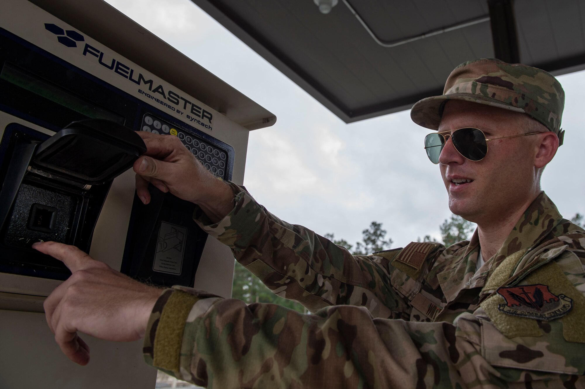 A photo of an Airman checking a vehicle interface link socket on a fuel service station