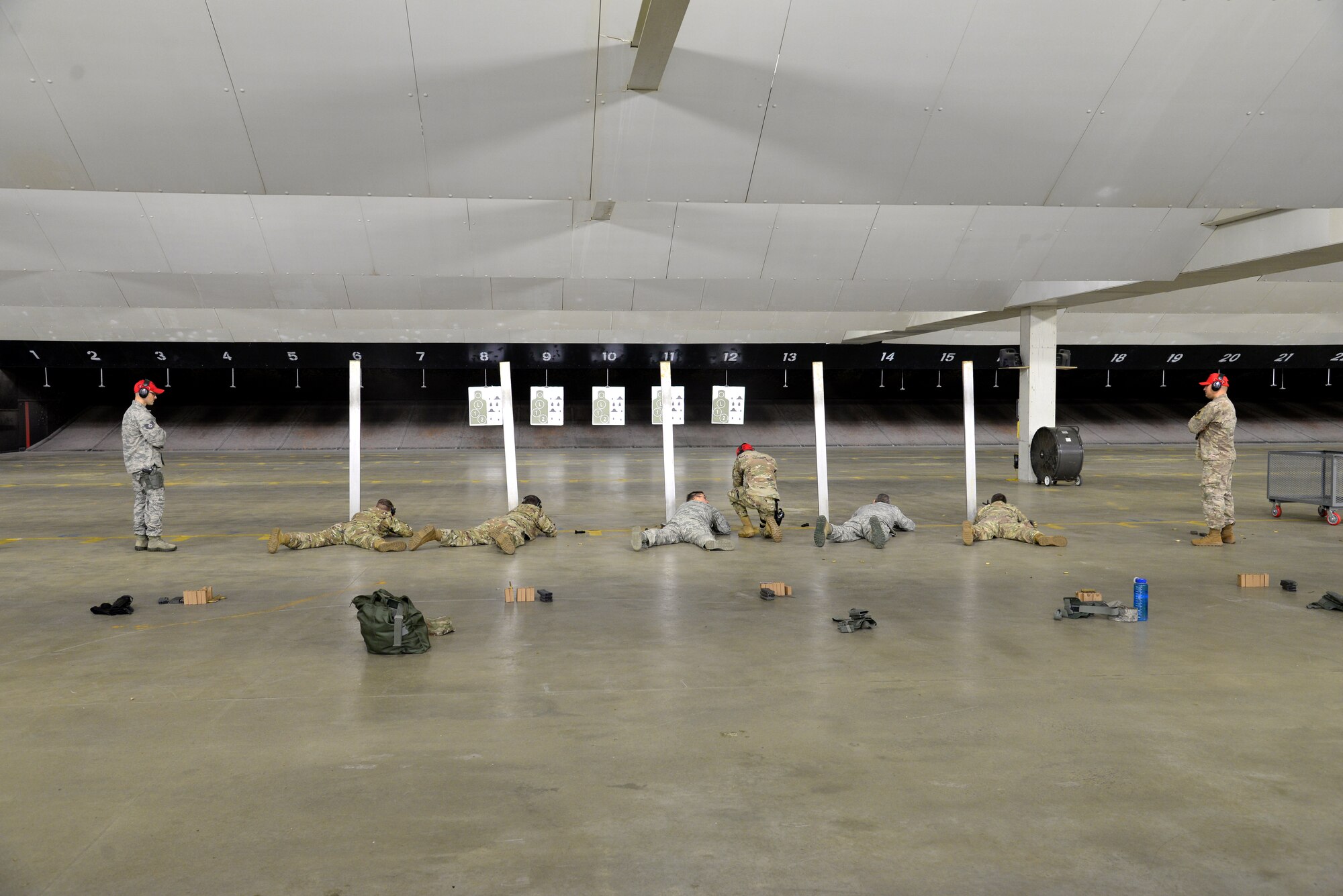 A picture of the wing commander and group commanders of the 177th Fighter Wing laying prone and firing the M4 carbine at a firing range.