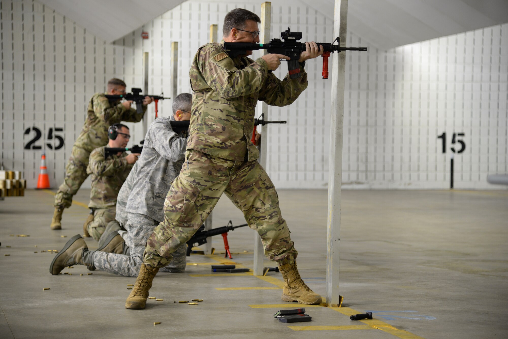 The Wing commander and group commanders of the 177th Fighter Wing shoot M4 carbines at a firing range.