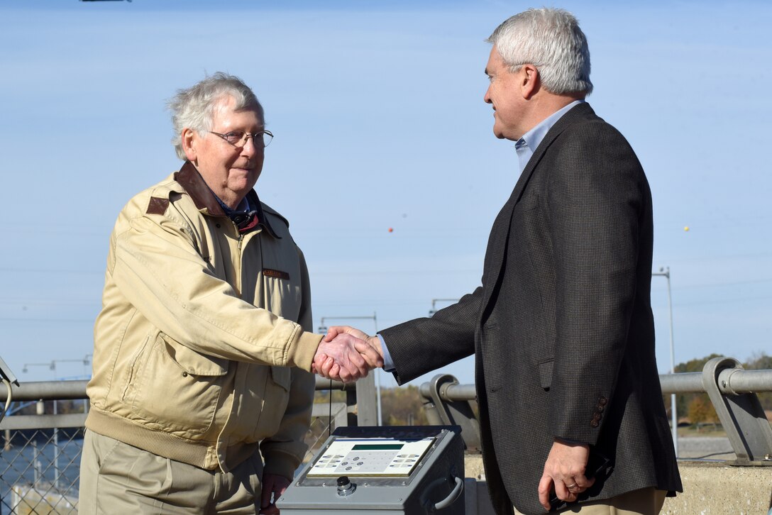 Senate Majority Leader Mitch McConnell (Left) and Congressman James Comer, Kentucky 1st District, congratulate each other after McConnell initiated a button to commission a bio-acoustic fish fence Nov. 8, 2019 below Barkley Lock in Grand Rivers, Ky. The BAFF sends a curtain of bubbles, sound and light from the riverbed to the water surface, which deters noise-sensitive Asian carp from entering the lock chamber. Fisheries managers on the west coast of the United States use a similar system to guide the movement of trout and salmon from water channels. This marks the first time a BAFF has been tested at a lock and dam on a large river. Construction of the BAFF began in July 2019. The project involves multiple partners, including U.S. Fish and Wildlife Service, Kentucky Department of Fish and Wildlife Resources, U.S. Army Corps of Engineers Nashville District, U.S. Geological Survey, and Tennessee Wildlife Resources Agency. Fish Guidance Systems, a United Kingdom-based company specializing in fish deflection and guidance systems, provided the BAFF technology at Barkley Lock.  (USACE photo by Lee Roberts)