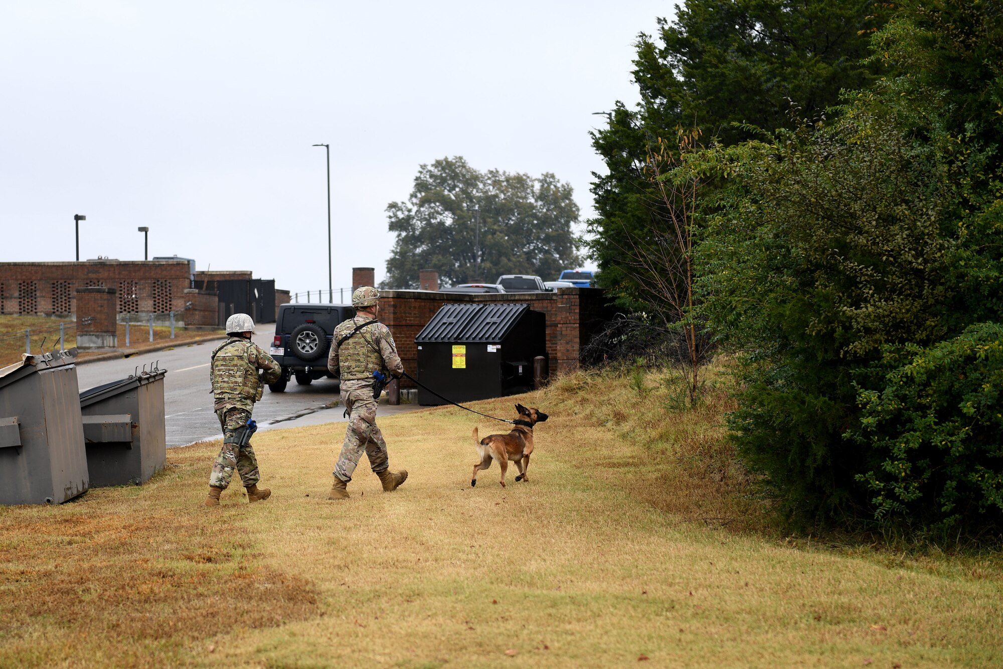 Men in uniform have dog.