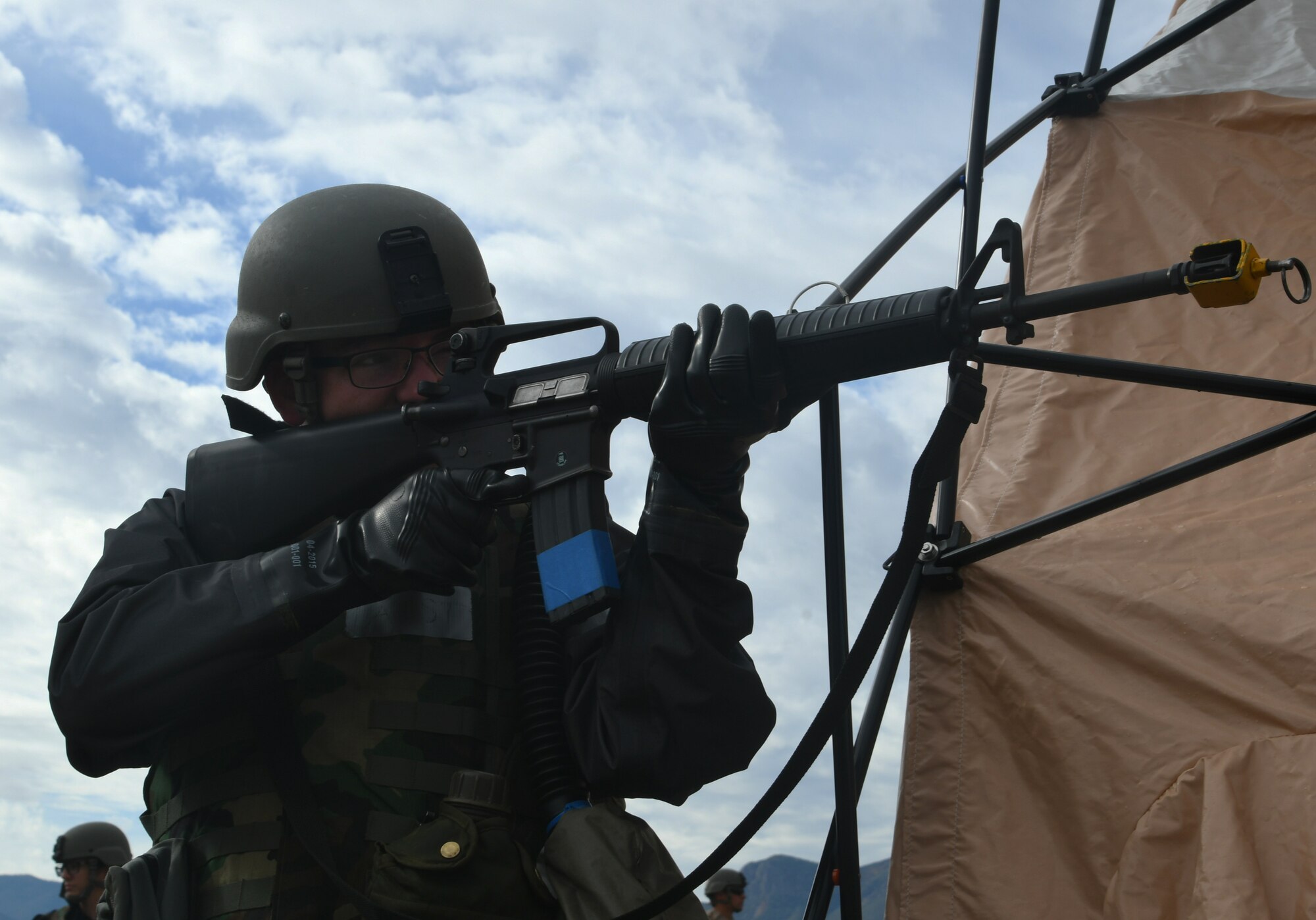 a photo of an airman working to defend the base during an exercise