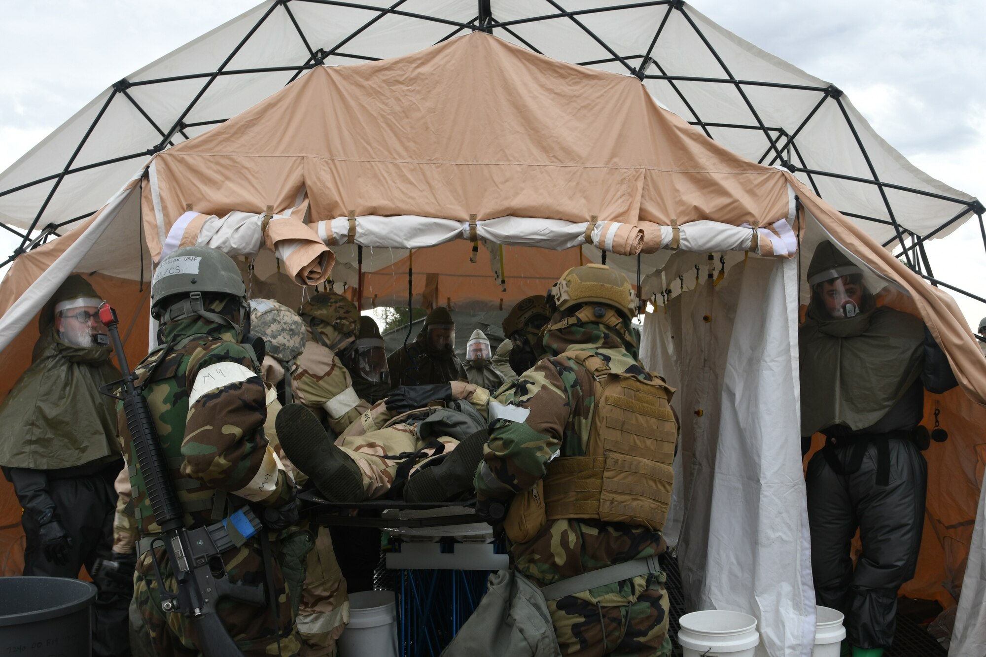 a photo of airmen working and wearing MOPP gear during an exercise