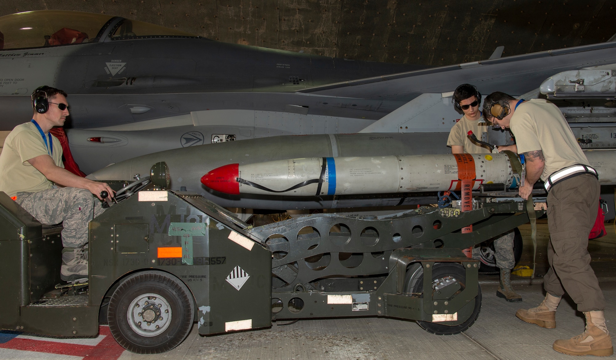 U.S. Air Force Staff Sgt. Nicolas Maurin, 52nd Aircraft Maintenance Squadron weapons load three-man crew member, left, Airman 1st Class Matthew Rondon, 52nd AMXS weapons load two-man crew member, middle-right, and Staff Sgt. Andrew Grimes, 52nd AMXS weapons load crew team chief, right, offload an inert missile from an F-16 Fighting Falcon using an MJ01 jammer at Uvda Air Base, Israel, November 5, 2019.