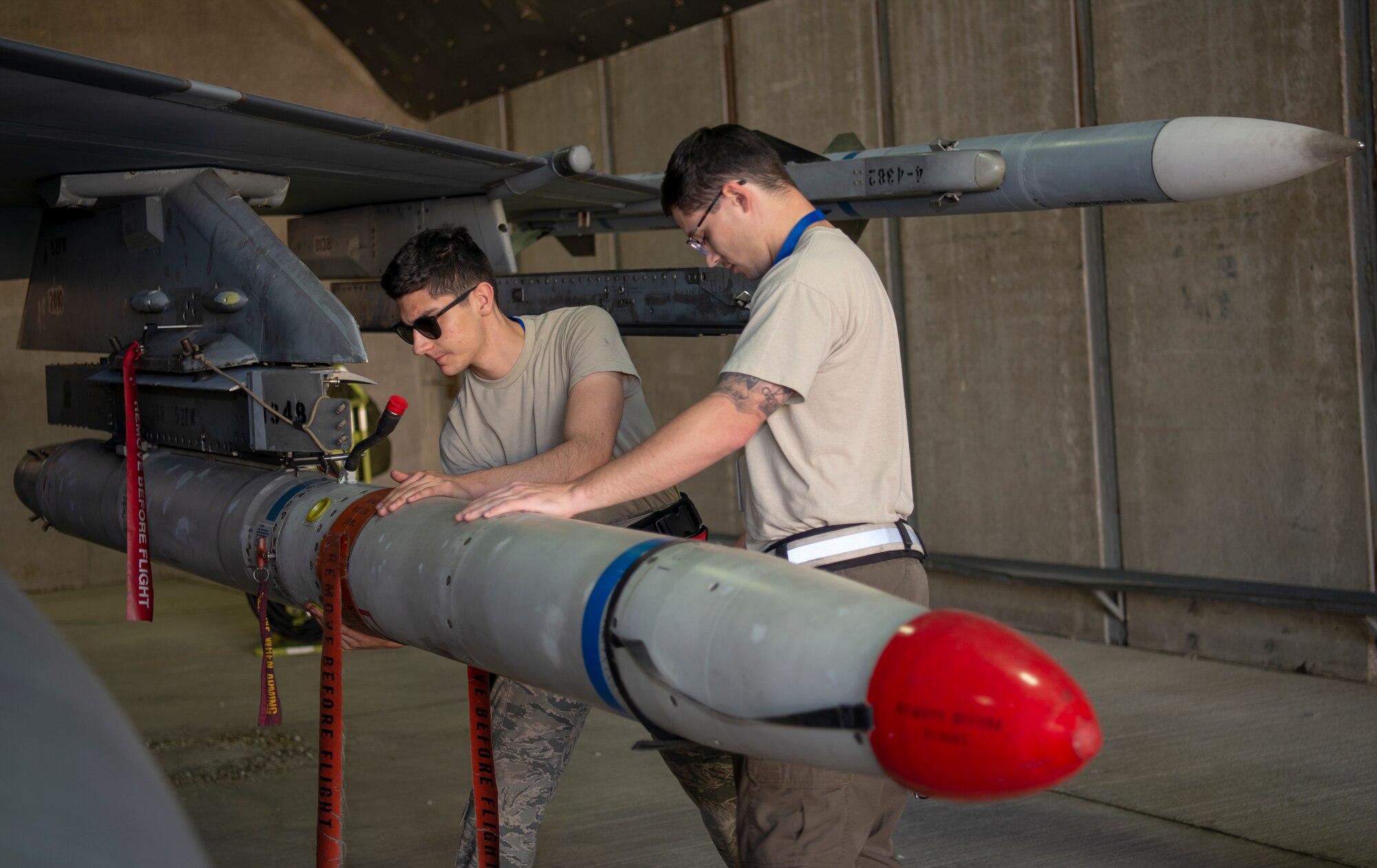 U.S. Air Force Airman 1st Class Matthew Rondon, 52nd Aircraft Maintenance Squadron weapons load two-man crew member, left, and Staff Sgt. Andrew Grimes, 52nd AMXS weapons load crew team chief, right, prepare to offload an inert missile from an F-16 Fighting Falcon at Uvda Air Base, Israel, November 5, 2019.