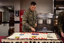 the commanding officer of the 11th Marine Expeditionary Unit (MEU), cuts a cake during a 244th Marine Corps birthday celebration