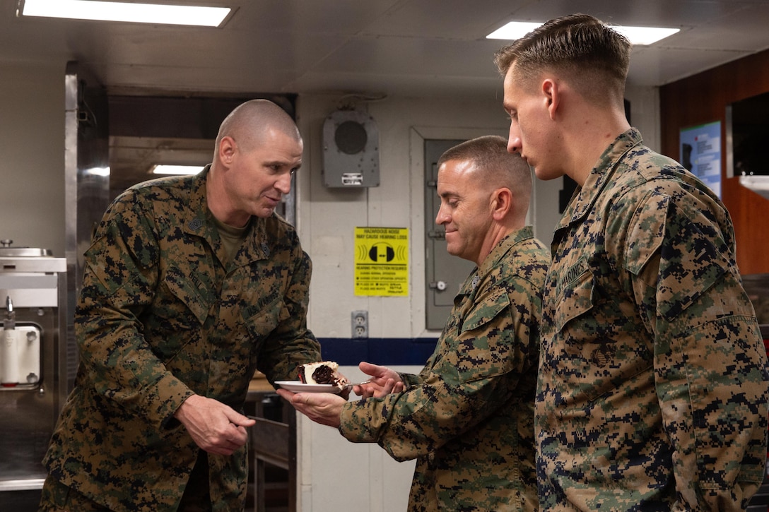 191110-M-EC058-1048 PACIFIC OCEAN (Nov. 10, 2019) U.S. Marine Corps Sgt. Maj. Charles Bell (left), the sergeant major of the 11th Marine Expeditionary Unit (MEU), passes a piece of cake to Sgt. Maj. Jonathan Morris, the sergeant major of Marine Medium Tiltrotor Squadron (VMM) 163 (Reinforced), 11th MEU and the oldest Marine present, during a 244th Marine Corps birthday celebration aboard the amphibious assault ship USS Boxer (LHD 4). The Marines and Sailors of the 11th MEU are conducting routine operations as part of the Boxer Amphibious Ready Group in the eastern Pacific Ocean. (U.S. Marine Corps photo by Cpl. Dalton S. Swanbeck)