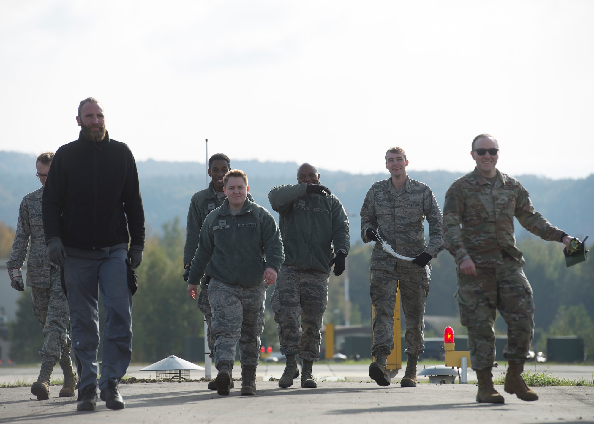 Members of the 786th Civil Engineer Squadron walk back to their cars after finishing runway maintenance at Ramstein Air Base, Germany, Oct. 28, 2019. Making sure the aircraft arresting system is ready at any moment is a daily job for power production technicians.