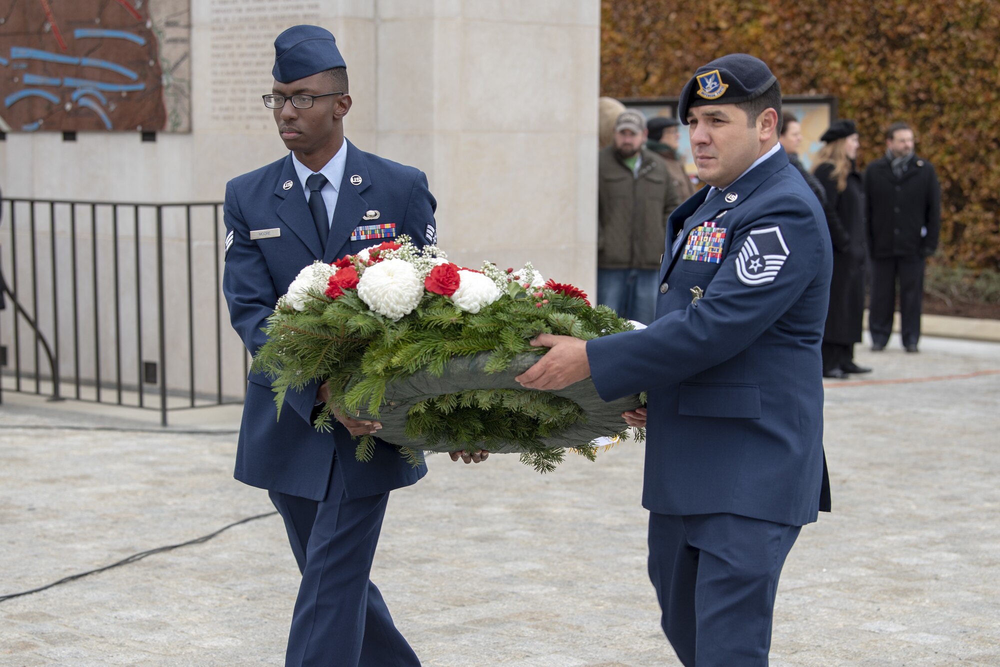 U.S. Air Force Senior Airman Brice Moore, 52nd Fighter Wing ground liaison analyst, and Master Sgt. Samuel Jalomo, 52nd Security Forces NCO in charge of operations, carry a wreath during the Veterans Day ceremony on the Luxembourg American Cemetery in Hamm, Luxembourg, Nov. 11, 2019. The cemetery is home to more than 5,000 service members who died during World War II, including U.S. Army Gen. George S. Patton. (U.S. Air Force photo by Airman First Class Branden Rae)