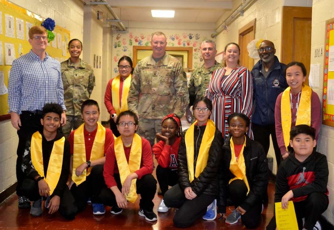 DLA Troop Support volunteers pose with students during a Veterans Day event at the Gilbert Spruance Elementary School Nov. 7, 2019 in Philadelphia.