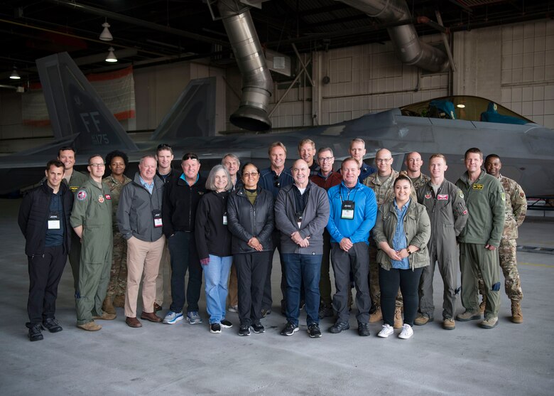 Participants of the Joint Civilian Orientation Conference pose for a photo at the Weapons Load Trainer hangar on Joint Base Langley-Eustis, Virginia, Nov. 7, 2019.