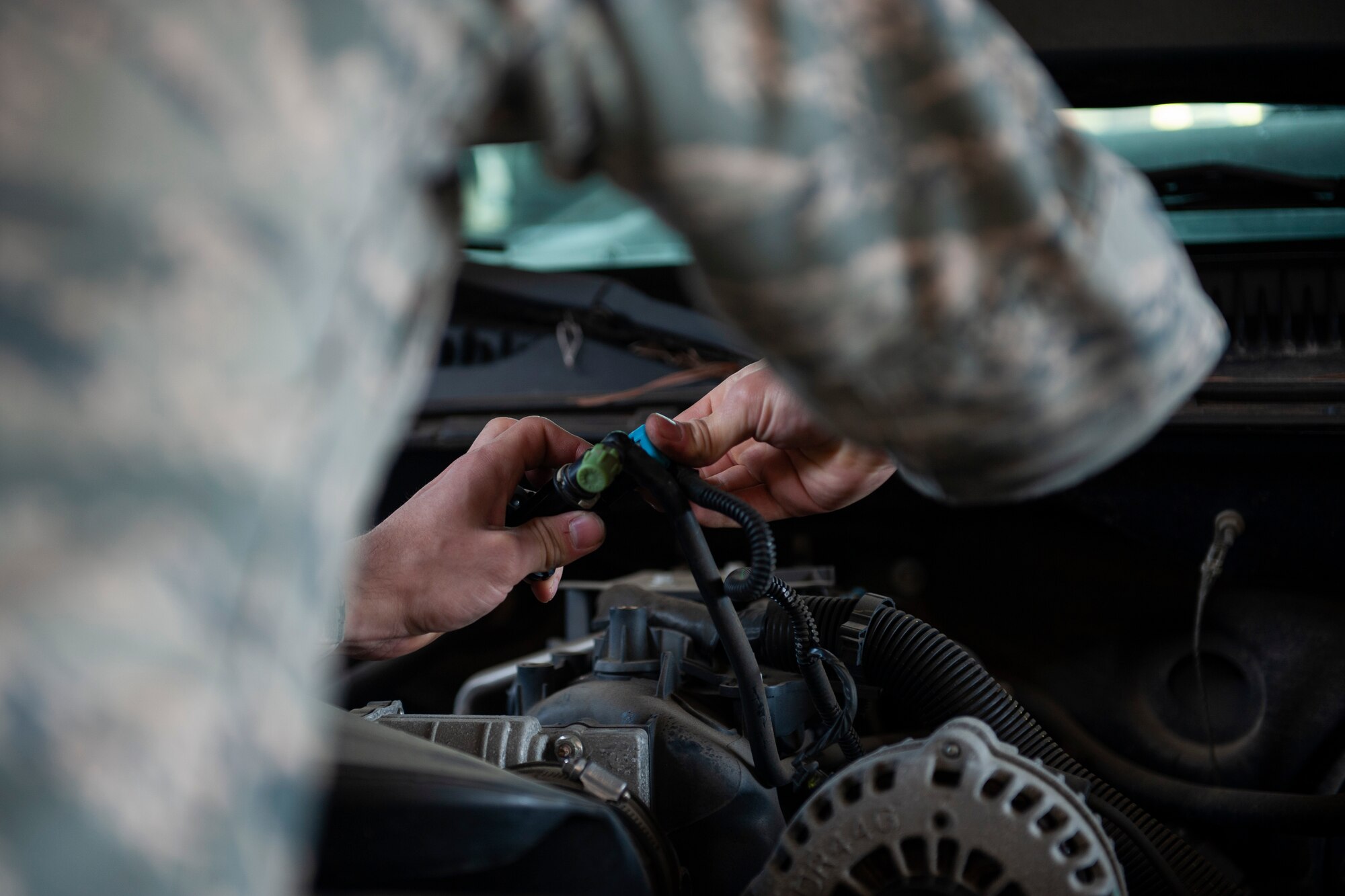 A photo of an Airman repairing a valve on a vehicle