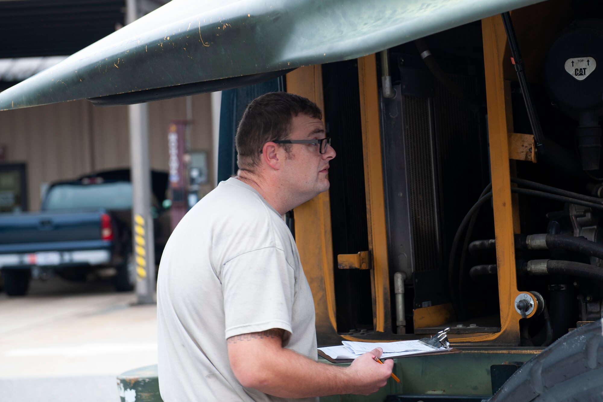 A photo of an Airman inspecting a forklift for maintenance