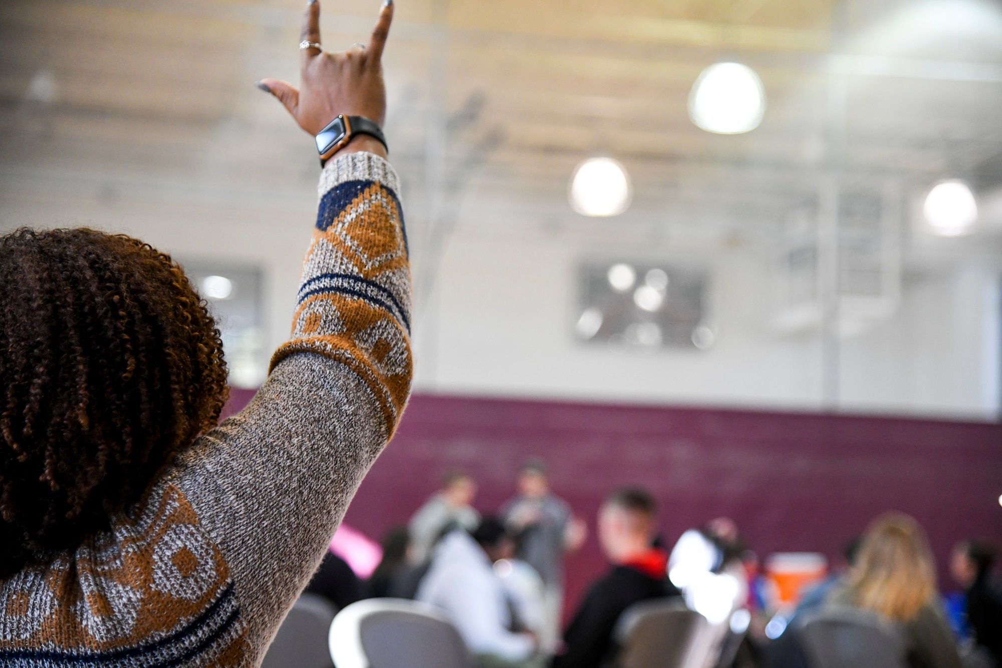A Challenge Day participant shows support for the person sharing their story by raising an “I love you” sign Nov. 4, 2019 at Peterson Air Force Base, Colorado. Challenge Day helps people learn to recognize internal and external social and emotional issues and pressures. (U.S. Air Force Photo by Erica Blanton)
