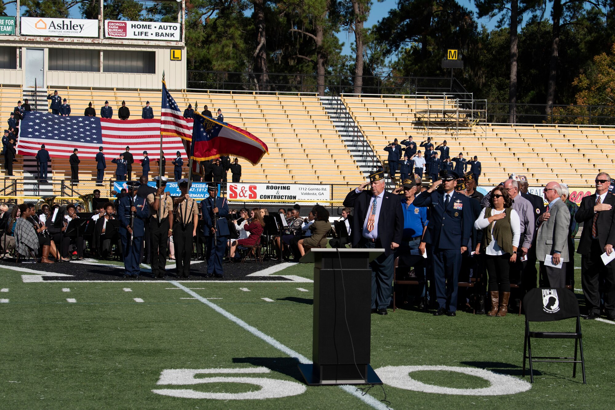 A photo of participants saluting during the National Anthem at a Veterans Day Observance
