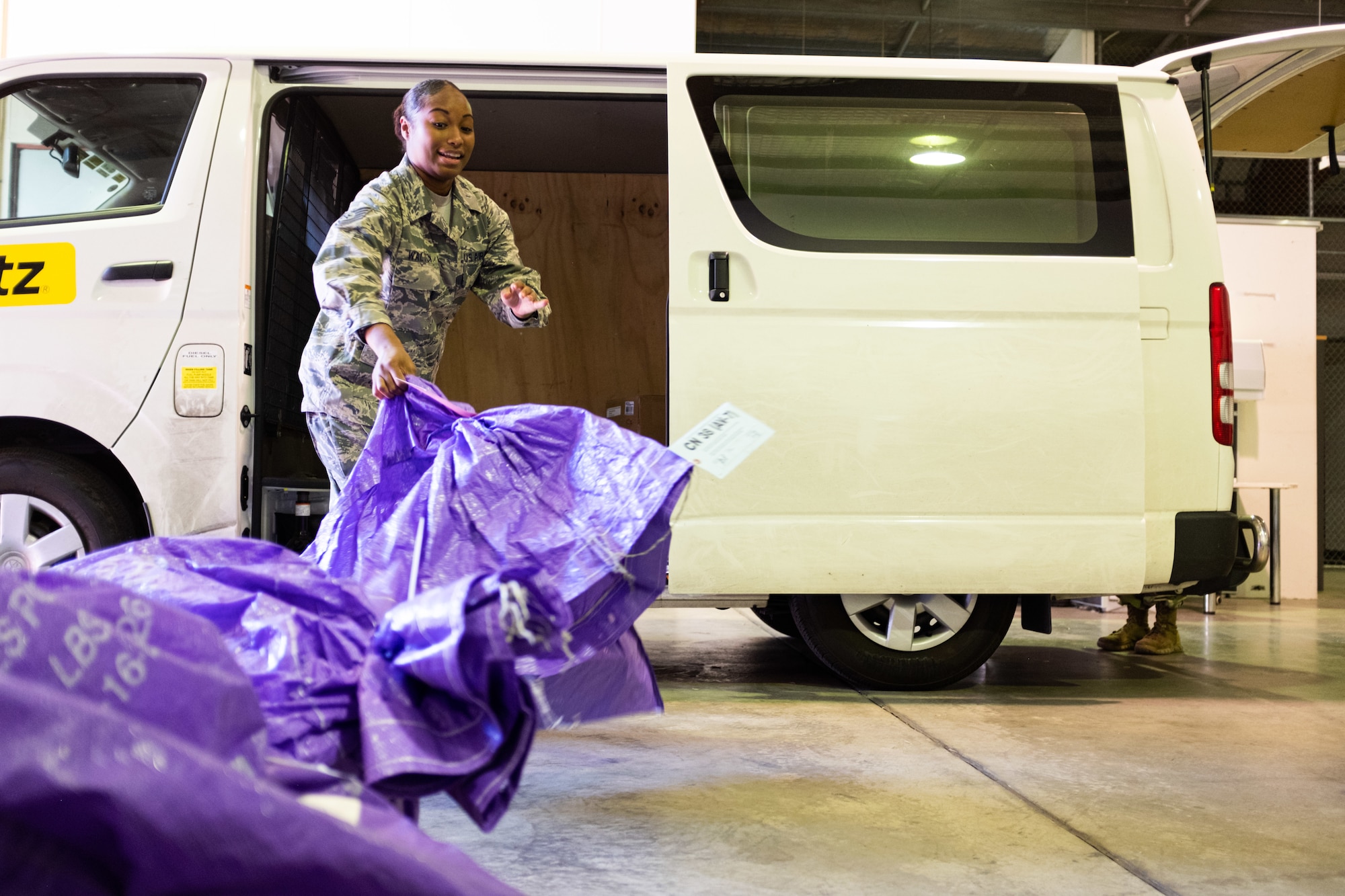 Tech. Sgt. Faneshia Walton, Pacific Air Forces Air Postal Squadron Det 4 aerial mail terminal chief, sorts incoming mail at the mail warehouse in Sydney, August 24, 2019. The detachment is responsible for delivering mail to government employees and their families located across an area of more than 3 million square miles. (U.S. Air Force Photo Illustration by Master Sgt. Benjamin Wilson)