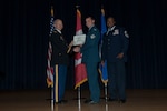 Sgt Jason Leslie (center) receives his Non-Commissioned Officer Academy certificate at Elmendorf Professional Military Education Center at Joint Base Elmendorf-Richardson in Alaska.