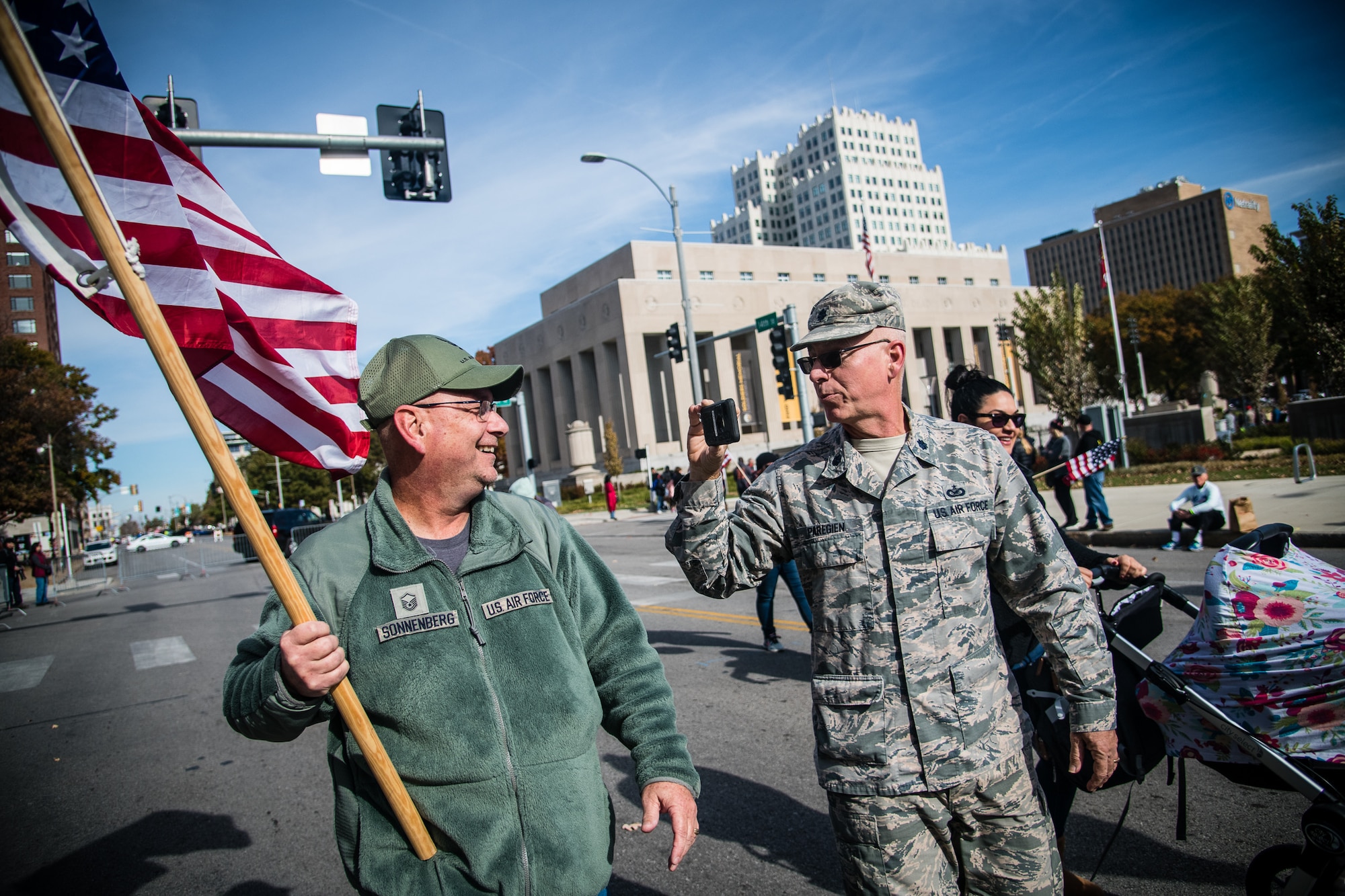 Lt. Col. Stan Paregien, 932nd Airlift Wing public affairs officer, right, takes video of former 932nd AW historian and now retired Master Sgt. Gerald Sonnenberg at the St. Louis Veterans Day Parade, downtown St. Louis, Missouri Nov. 9, 2019. Sonnenberg continues to support local parades as an attendee but he also crafted the various flags carried by the 932nd AW during parades to showcase various historical U.S. flags. (U.S. Air Force photo by Christopher Parr)