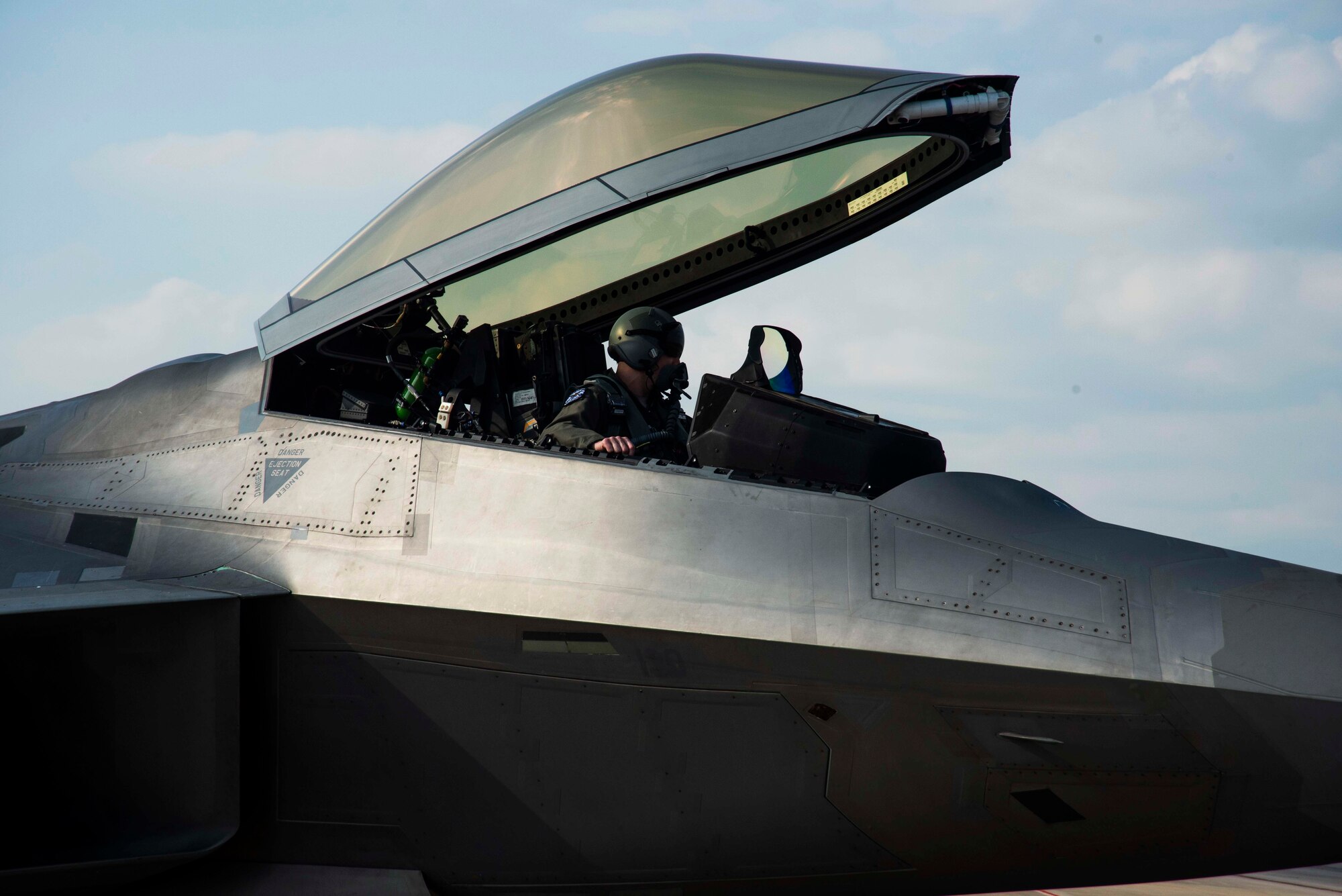 A pilot of an F-22 Raptor poses for a photo Nov. 6, 2019, at Tyndall Air Force Base, Florida. The pilot, airframe, and maintenance team supported Checkered Flag 20-1, which is a large-scale aerial exercise designed to integrate fourth and fifth-generation airframes to enhance mobility, deployment, and employment capabilities of aviators and maintainers. The exercise involved airpower assets, more than 50 aircraft, and support personnel from multiple installations. Aircraft and pilots participated in a Weapons System Evaluation Program and are evaluated on air-to-air and air-to-ground operations, providing a unique training environment. (U.S. Air Force photo by Staff Sgt. Magen M. Reeves)