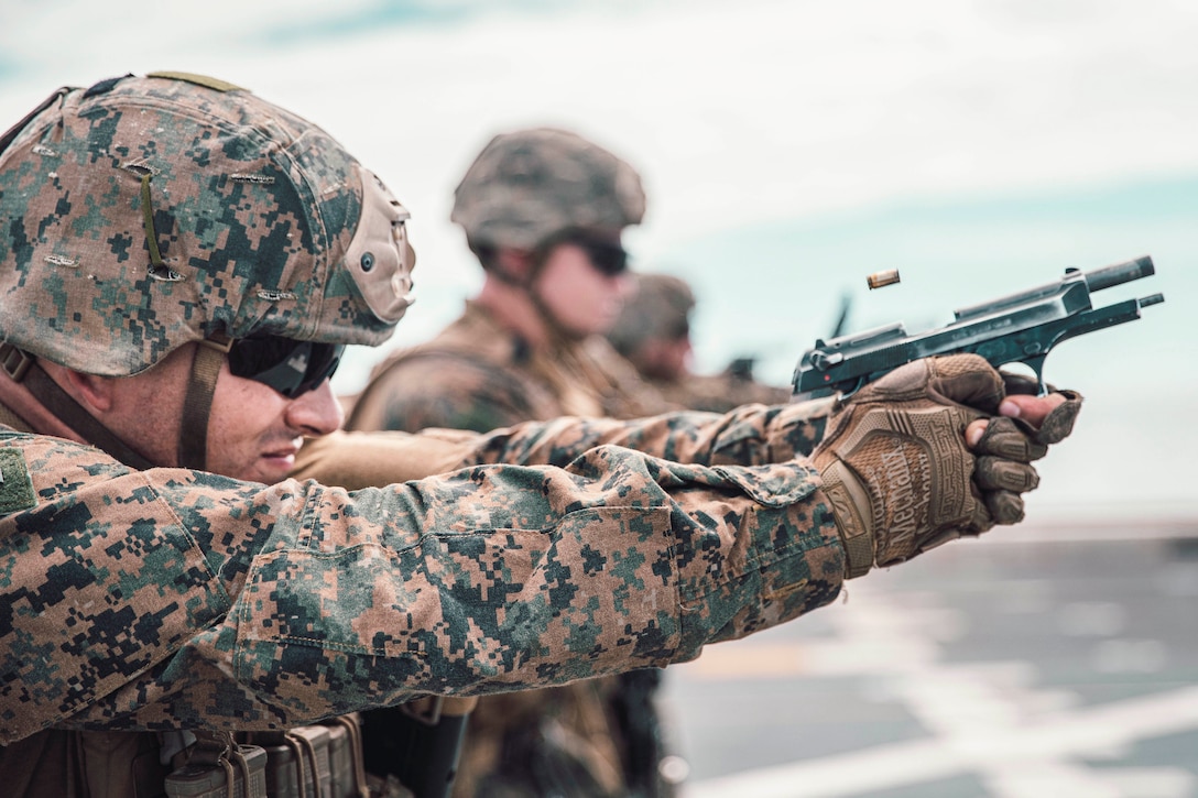 A Marine shoots a pistol.
