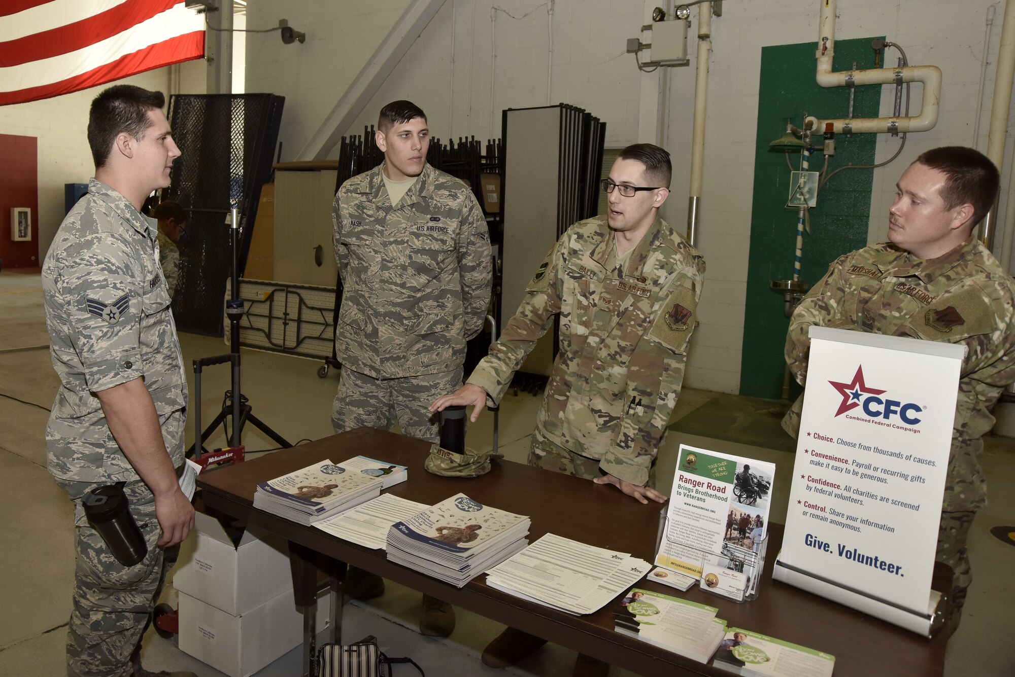 A photo of an Airman speaking to Combined Federal Campaign group representatives at a CFC booth