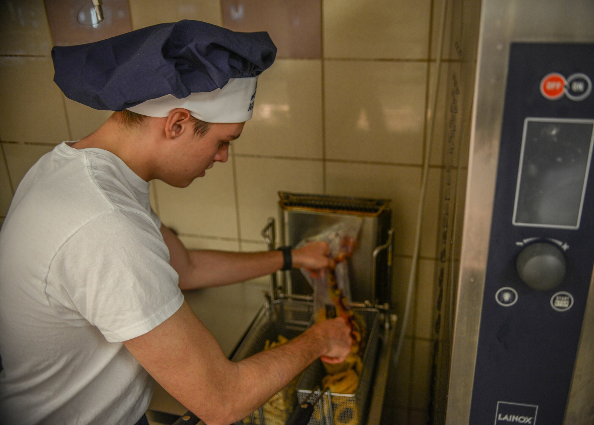 U.S. Airman Kellan S. Hill, 31st Force Support Squadron server, makes onion rings at La Dolce Vita dining facility, Aviano Air Base, Italy, Nov. 7, 2019. La Dolce Vita serves breakfast, lunch and dinner every day. (U.S. Air Force photo by Airman Thomas S. Keisler IV)