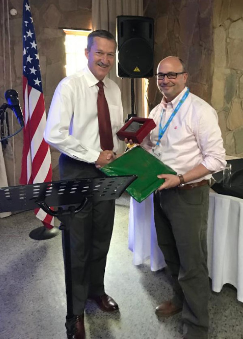 South African Brig. Gen.Carel Laubscher, (left) director of Education Training and Development Systems Integrity of the Human Resources Division, Republic of South Africa Department of Defense, receives a gift from New York Army National Guard Brig. Gen. Michel Natali, the assistant adjutant general for Army, during the annual defense committee meeting between South African and U.S. officials in Pretoria, South Africa, Nov. 6, 2019. The New York National Guard has had a State Partnership Program training and exchange relationship with the South African National Defence Force since 2003.