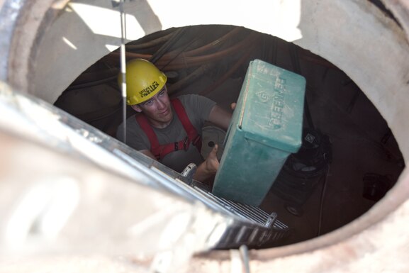 Senior Airman Blase Nyberg, 210th Engineering Installation Squadron cable and antenna systems specialist, cleans up his work area while installing fiber optic cable at Prince Sultan Air Base, Saudi Arabia on Nov. 5, 2019.