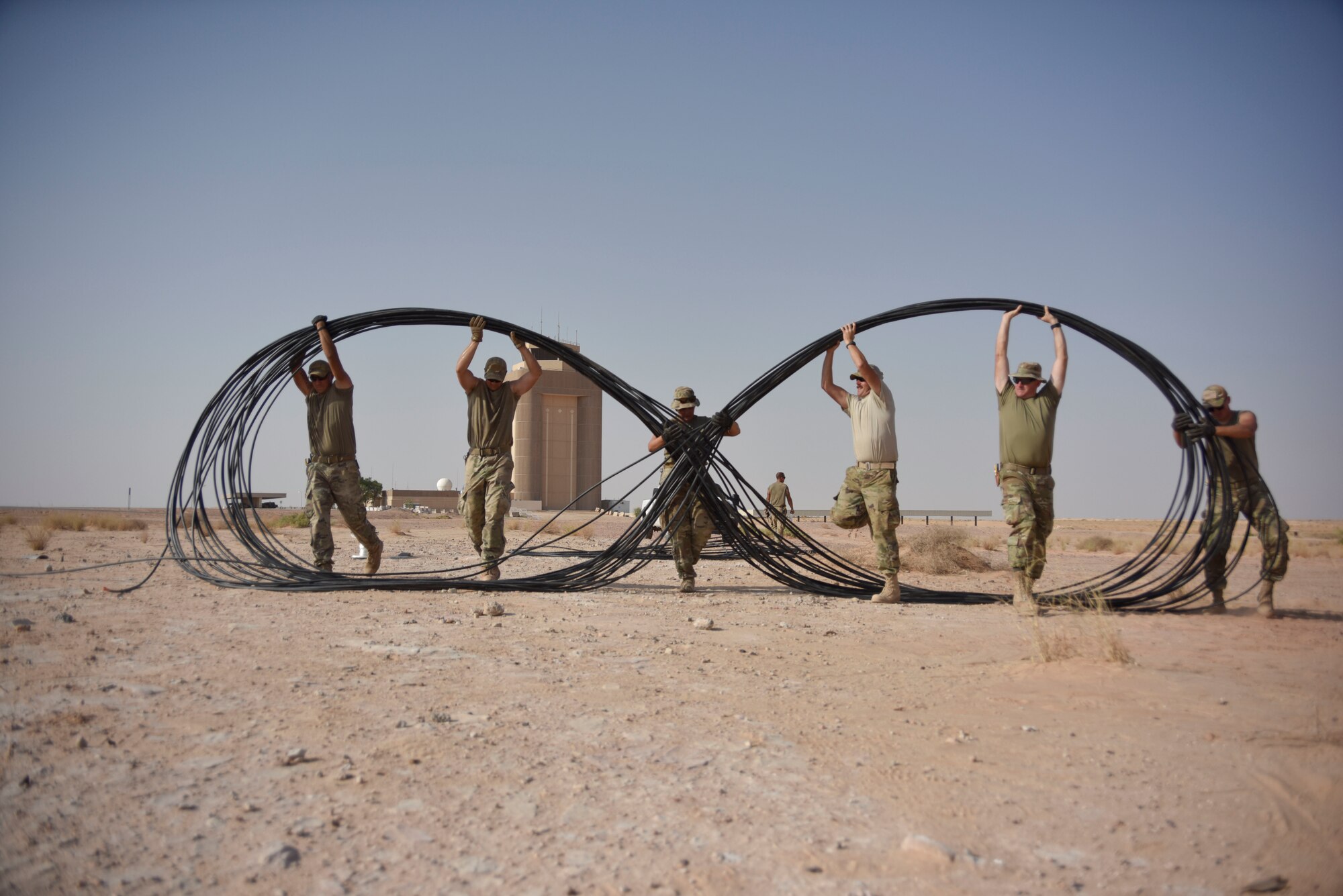 Airmen with the 210th Engineering Installation Squadron move fiber optic cable into place prior to running it to the next access point at Prince Sultan Air Base, Saudi Arabia on Nov. 5, 2019.