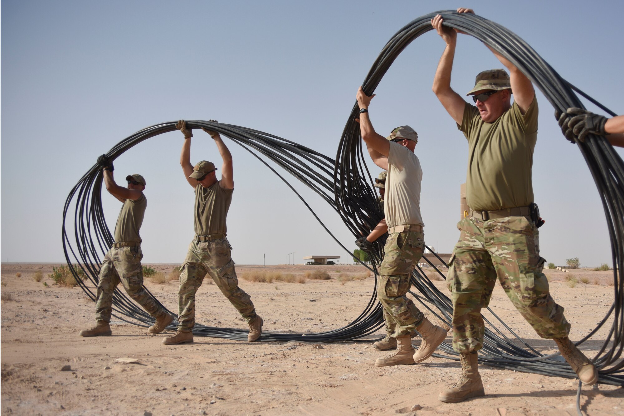 Airmen with the 210th Engineering Installation Squadron move fiber optic cable into place prior to running it to the next access point at Prince Sultan Air Base, Saudi Arabia on Nov. 5, 2019.