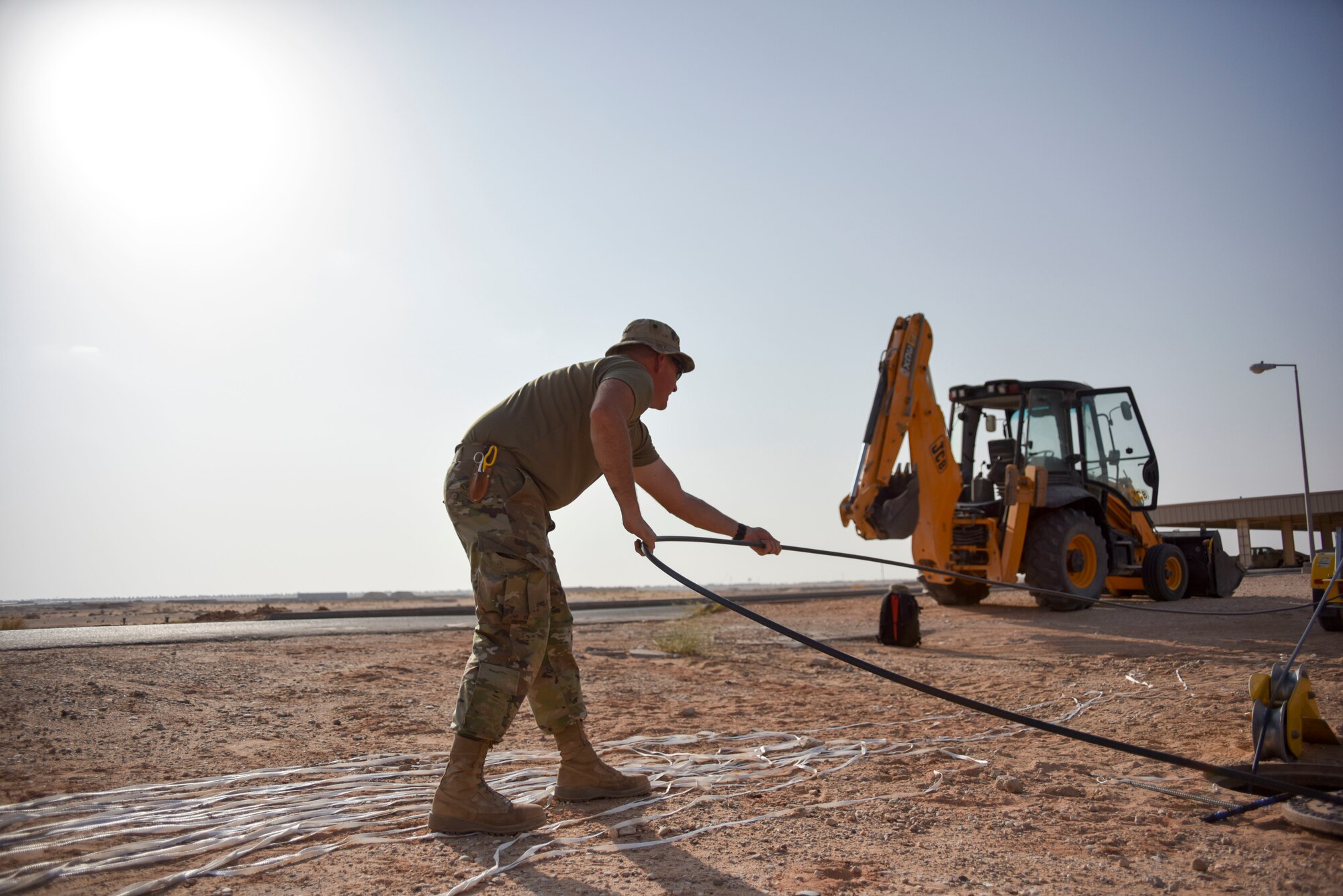 Master Sgt. Drew Gordon, 210th Engineering Installation Squadron cable installation team chief, guides fiber optic cable out of an access point at Prince Sultan Air Base, Saudi Arabia on Nov. 5, 2019.