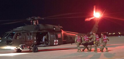 Soldiers load a simulated casualty onto a waiting UH-60 Black Hawk helicopter at Joint Base San Antonio-Kelly Airfield as part of a U.S. Army Forces Command Emergency Deployment Readiness Exercise Nov. 4, 2019. The exercise tested Brooke Army Medical Center staff’s ability to receive and provide definitive care to wartime trauma victims, as part of its Role IV wartime mission.