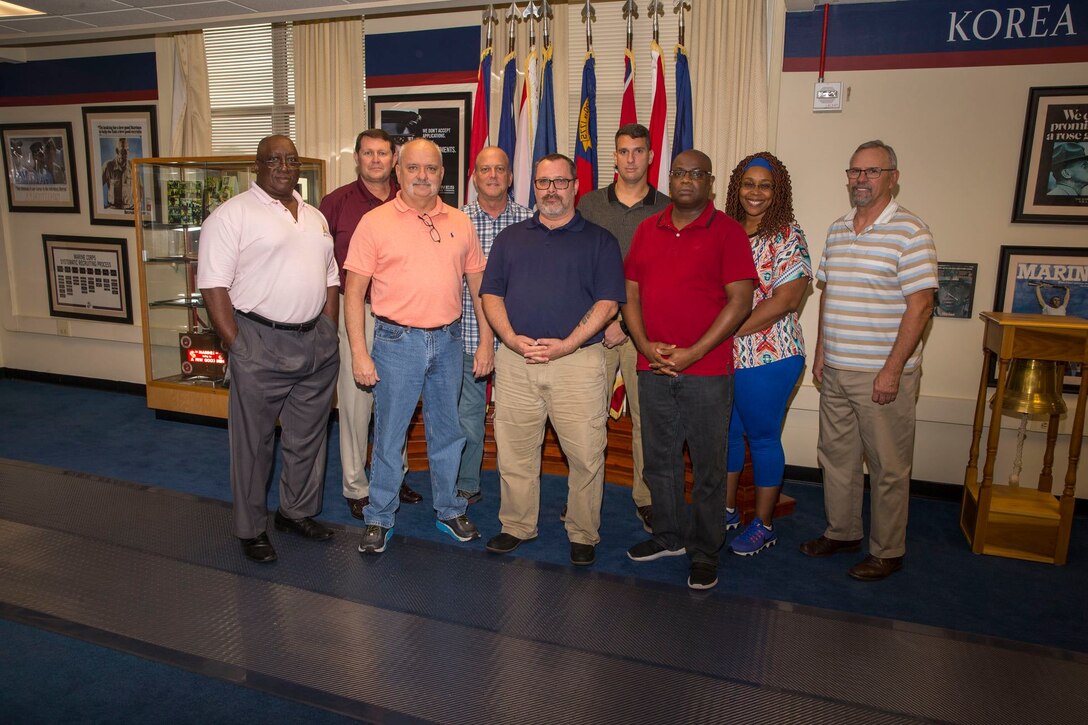 Civilian staff of 6th Marine Corps District pose for a group photo in observance of Veteran's Day at the 6MCD Headquarters aboard Marine Corps Recruit Depot Parris Island, South Carolina on Nov. 8, 2019. Each individual served in the military and contine to support the Marine Corps recruiting mission. (U.S. Marine Corps photo by Sgt. Jorge Rosales)