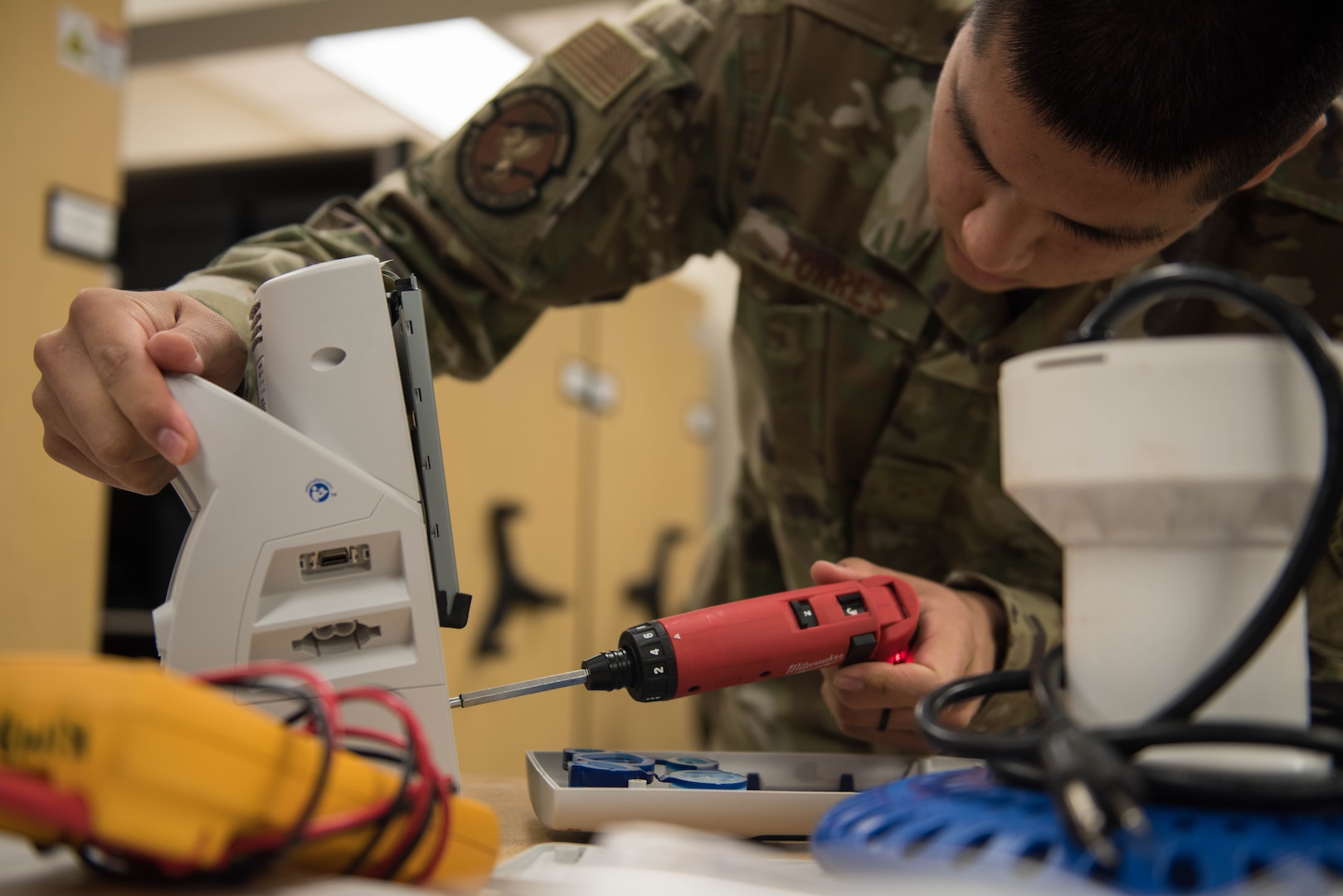 U.S. Air Force Airman 1st Class Timothy Torres, 633rd Medical Group biomedical equipment technician, unscrews a panel on a vital signs monitor at Joint Base Langley-Eustis, Virginia, Nov. 8, 2019. Torres removed the panel so the motor could be repaired. (U.S. Air Force photo by Airman 1st Class Sarah Dowe)