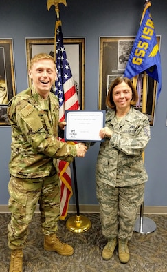 Master Sgt. Angela Hayden, 14th Intelligence Squadron first sergeant, presents the September 2019 Diamond Sharp Award to Senior Airman Robert Stephens, 14th IS Intelligence analyst, Nov. 6, 2019. The award is for exemplary performance, adherence to the Air Force Core Values, attitude, appearance and ability. (Courtesy photo)