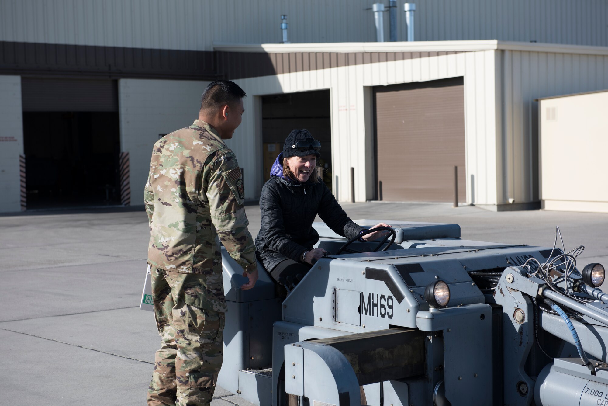 U.S. Air Force Airman from the 366th Maintenance Squadron aerospace ground equipment journeyman teaches Lauren McLean, Boise City Council president, to drive a jammer, November 7, 2019, on Mountain Home Air Force Base, Idaho. The AGE flight is responsible for maintaining equipment that supports aircraft systems. (U.S. Air Force photo by Airman Natalie Rubenak)