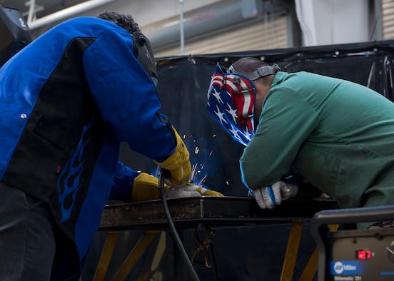 U.S. Air Force Airman and a city representative weld sheet metal together, November 7, 2019, on Mountain Home Air Force Base, Idaho. Civic leaders were able to weld sheet metal and use a sand cutter to cut out shapes of Idaho. (U.S. Air Force photo by Airman Natalie Rubenak)