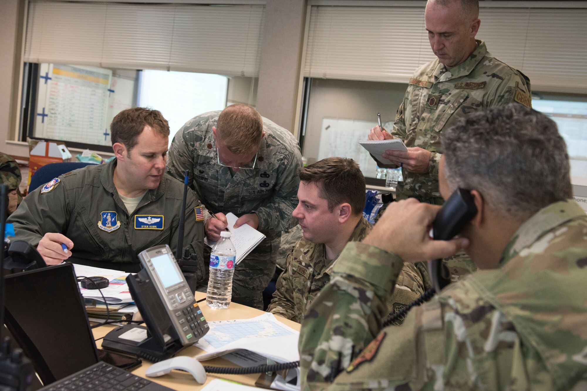 Airmen assigned to the emergency operation center, command post and crisis action team share information to make decisons during a full-scale readiness exercise, Nov. 5, 2019.  Approximately 300 members of the 167th Airlift Wing deployed to the Combat Readiness Training Center in Alpena, Mich., Nov. 3-7, for the event. (U.S. Air National Guard photo by Senior Master Sgt. Emily Beightol-Deyerle)