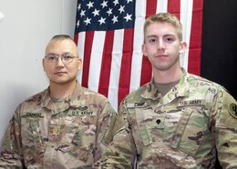 Maj. William Gaefcke, and Spc. Travis Camp, 103rd Expeditionary Sustainment Command, stand in front of a U.S. flag, which they used as backdrop while connecting with a Veterans Day assembly at Ladd Pre-Kindergarten through 8th Grade Consolidated School via teleconference Nov. 11, 2019. Gaefcke and Camp, who are currently deployed to Camp Arifjan, Kuwait, are expected to return home Spring 2020.