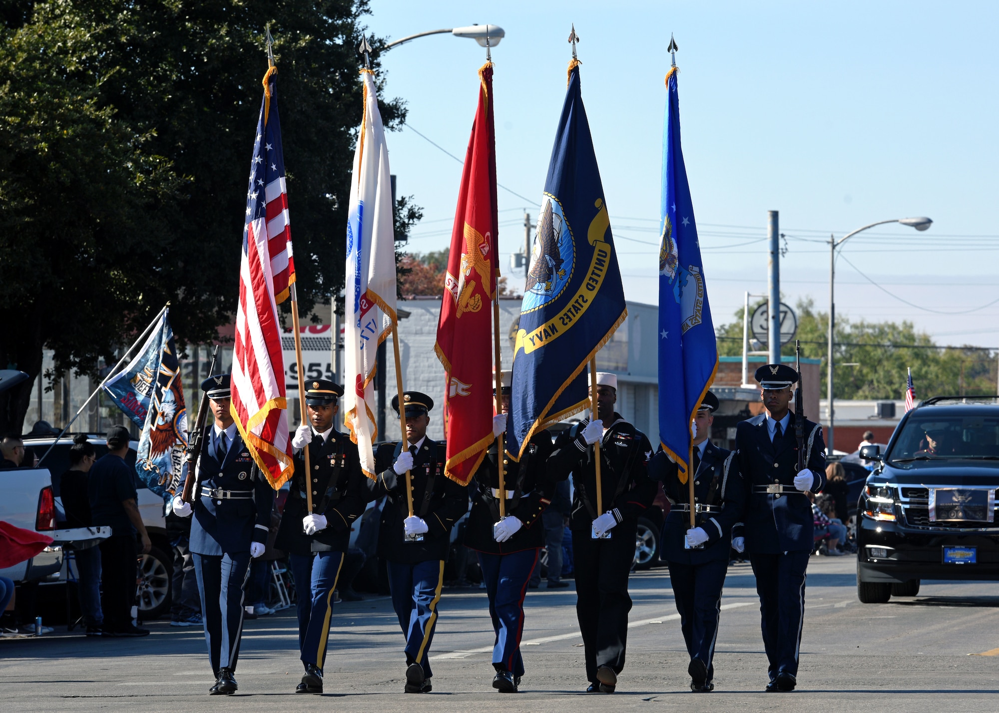 The Joint Service Color Guard marches with the American Flag and the various military branch flags during the Veterans Day Parade in San Angelo, Texas, Nov. 9, 2019. Veterans Day is a day dedicated to the patriotism and duty of those who have served. (U.S. Air Force photo by Airman 1st Class Robyn Hunsinger/Released)