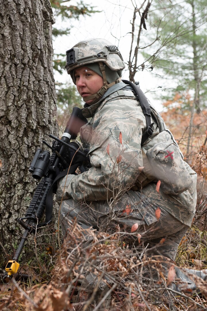 Master Sgt. Tammy Marks, 167th Secuirty Forces Squadron, kneels in a wooded area during a comabt training scenario, Nov. 5, 2019. Approximately 300 members of the 167th Airlift Wing, Martinsburg, W.Va., deployed to the Combat Readiness Training Center in Alpena, Mich., Nov. 3-7, for a full-scale readiness exercise.